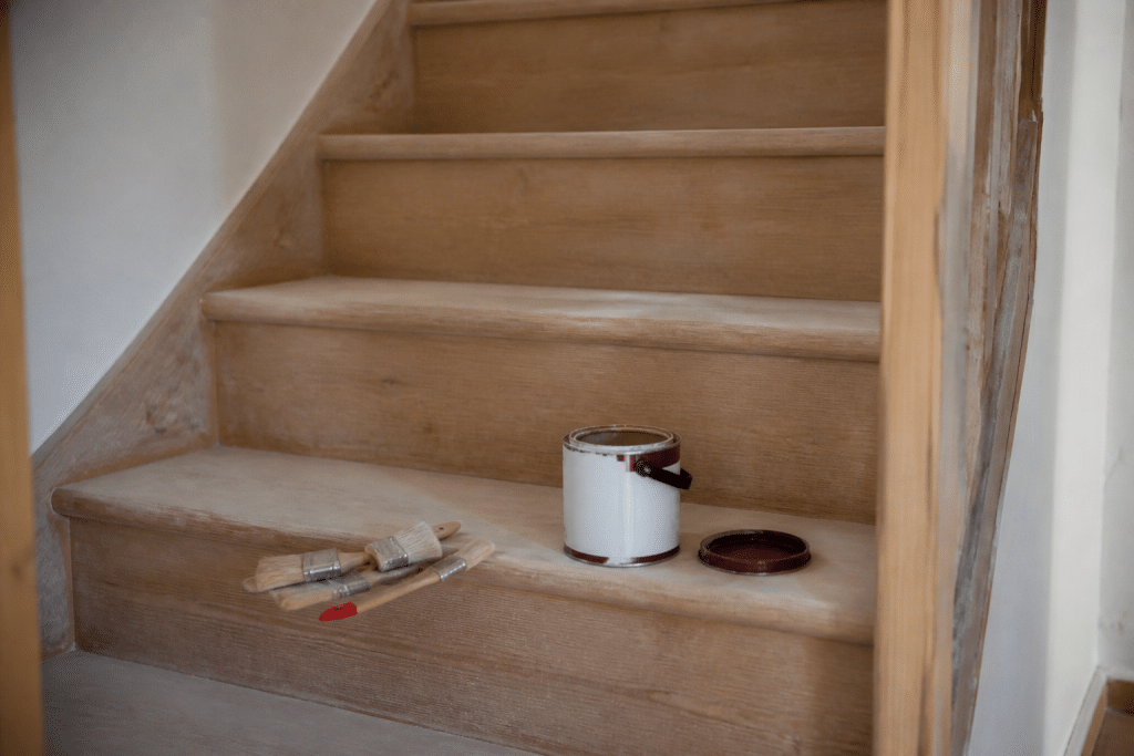 Escalier en bois ponce avec pinceaux et peinture prepares