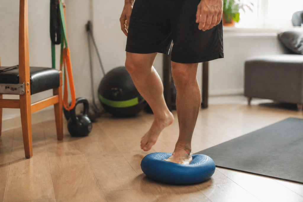 Personne effectuant exercices équilibre sur coussin instable