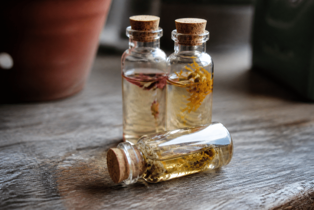 Fioles de verre avec liquide clair et pétales de fleurs séchées
