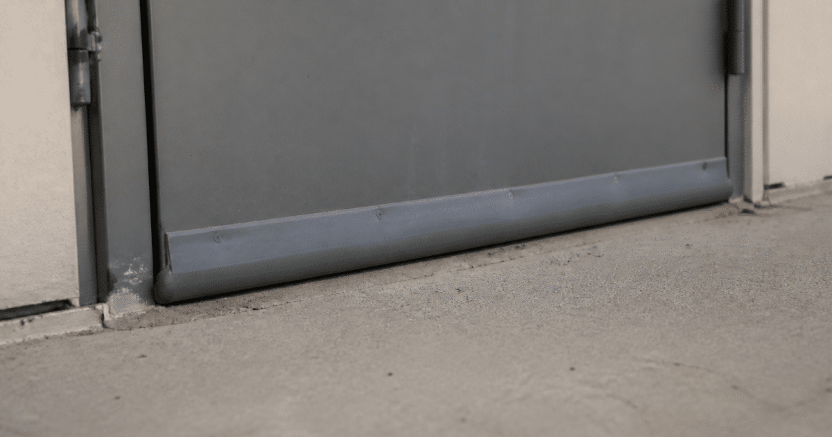 Bande d'etancheite grise fixee au bas d'une porte metallique