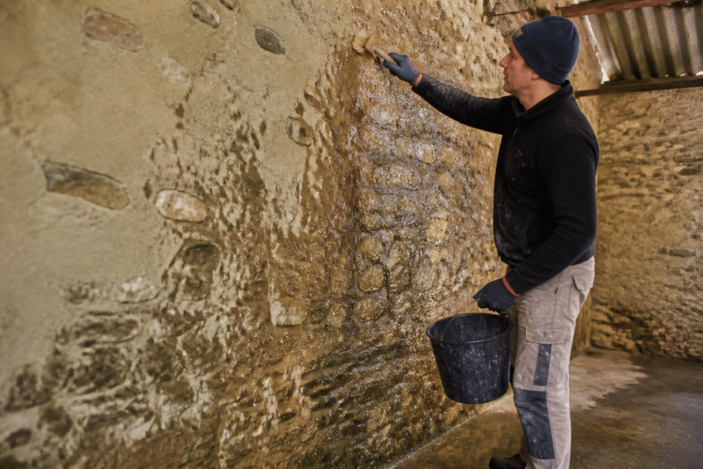 Mur ancien humidifié avant application enduit naturel